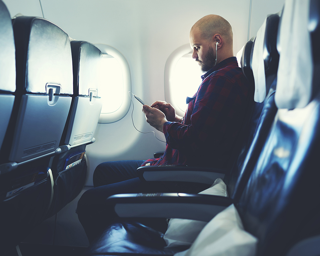 Man using device on plane