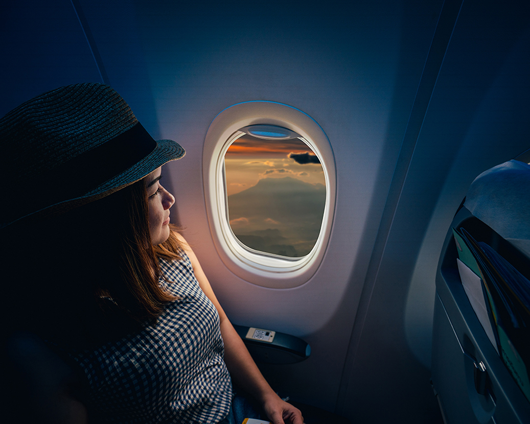 woman looking out airplane window