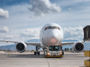 Jet aircraft being pulled by tractor while taxiing