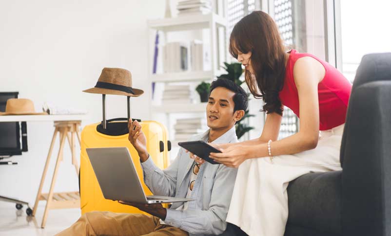 couple using computer to find flights while traveling